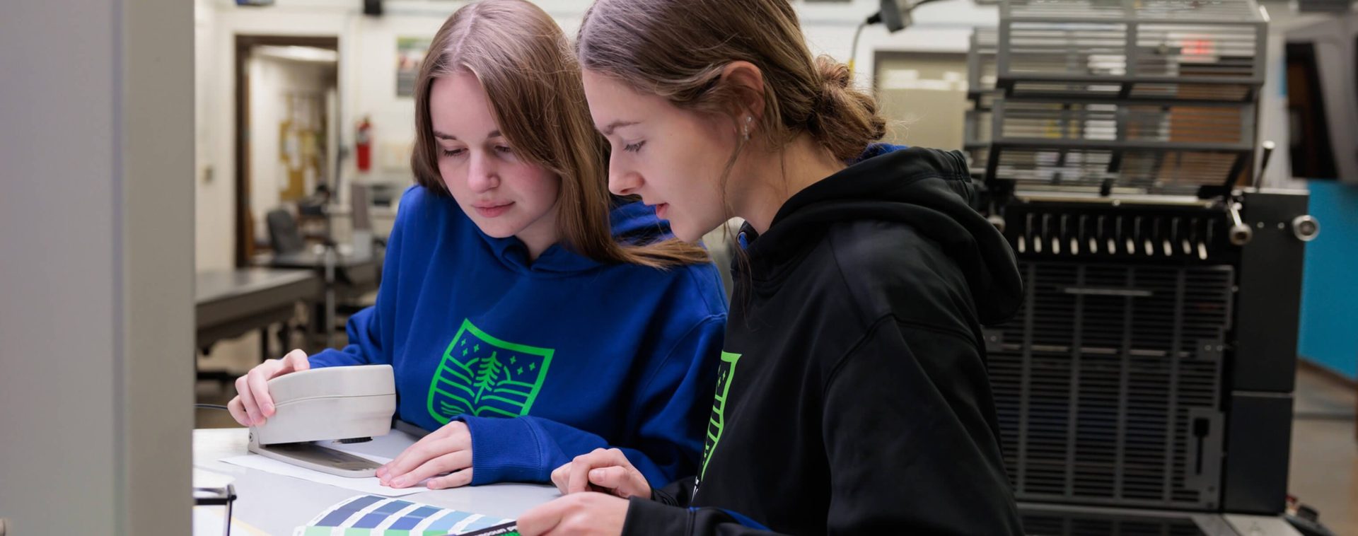 Two students look at color swatches in a workshop.