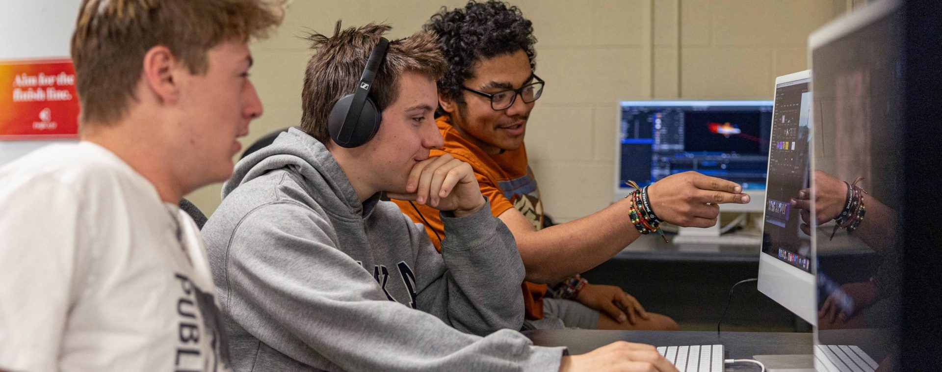 Students looking at a computer screen discussing things.