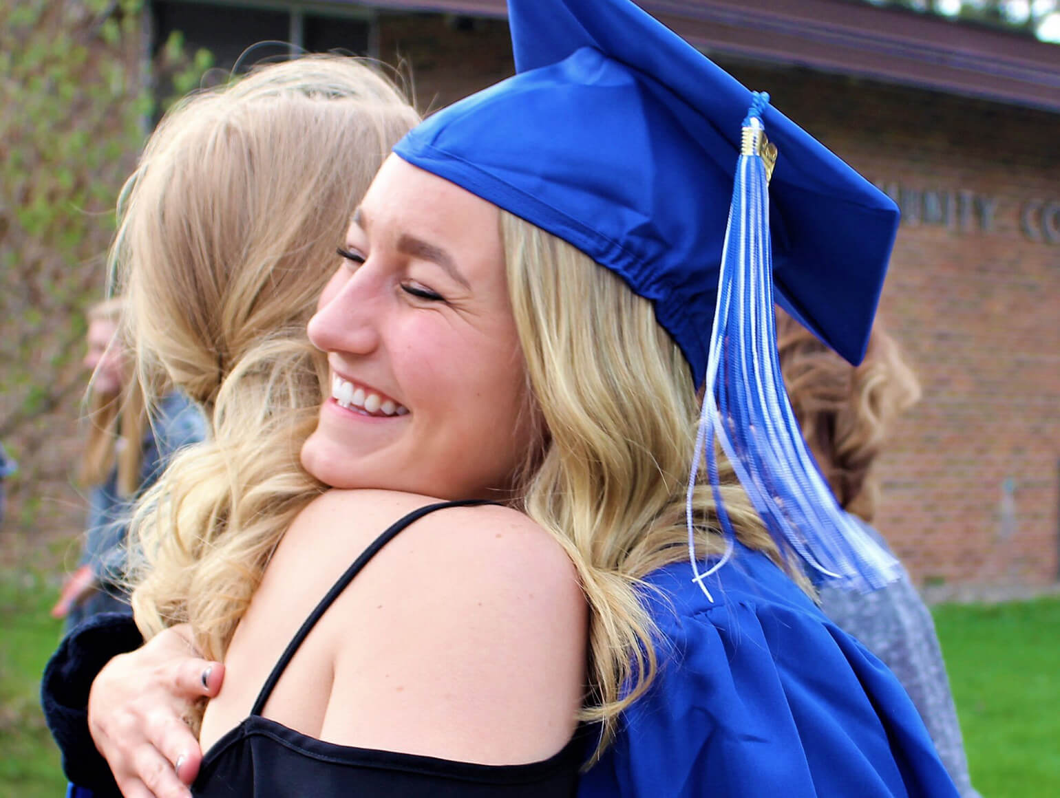 Minnesota North College student graduates and hugs a family member.