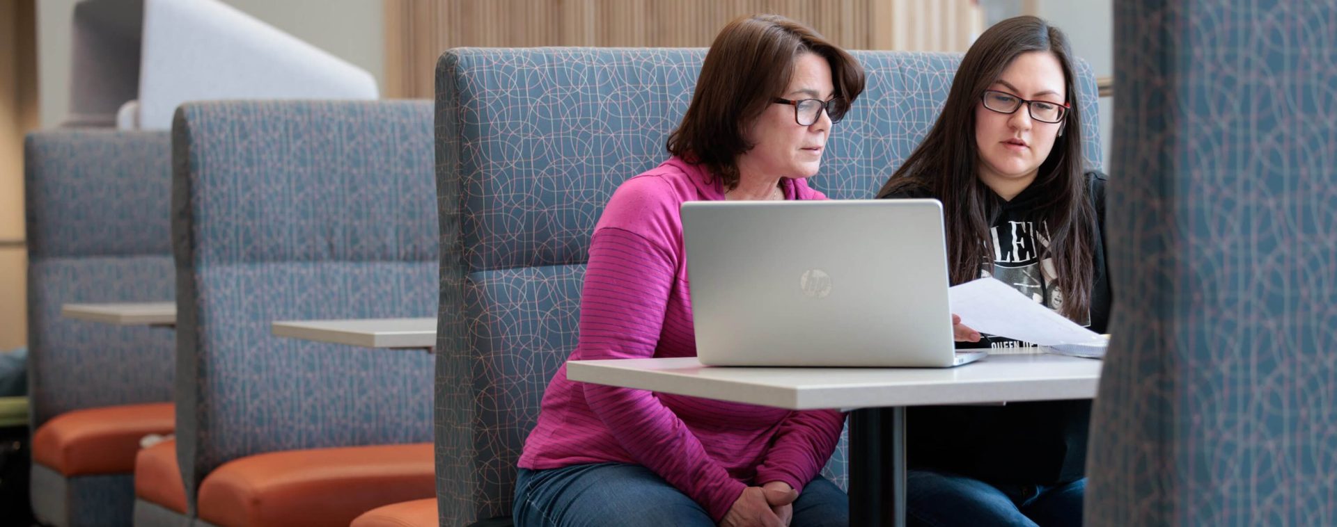 Women in booth on a computer