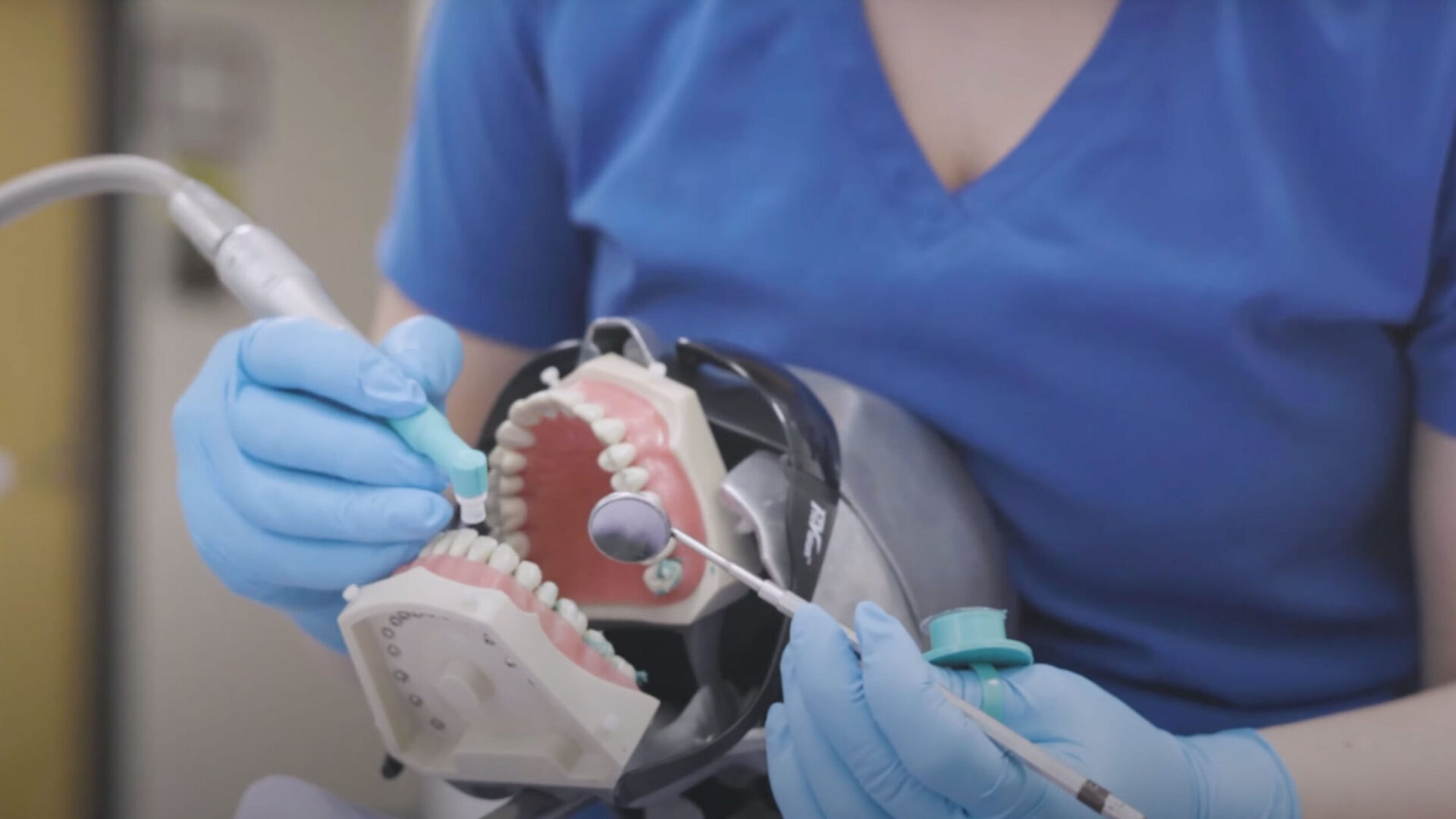 Dental student practicing in classroom.