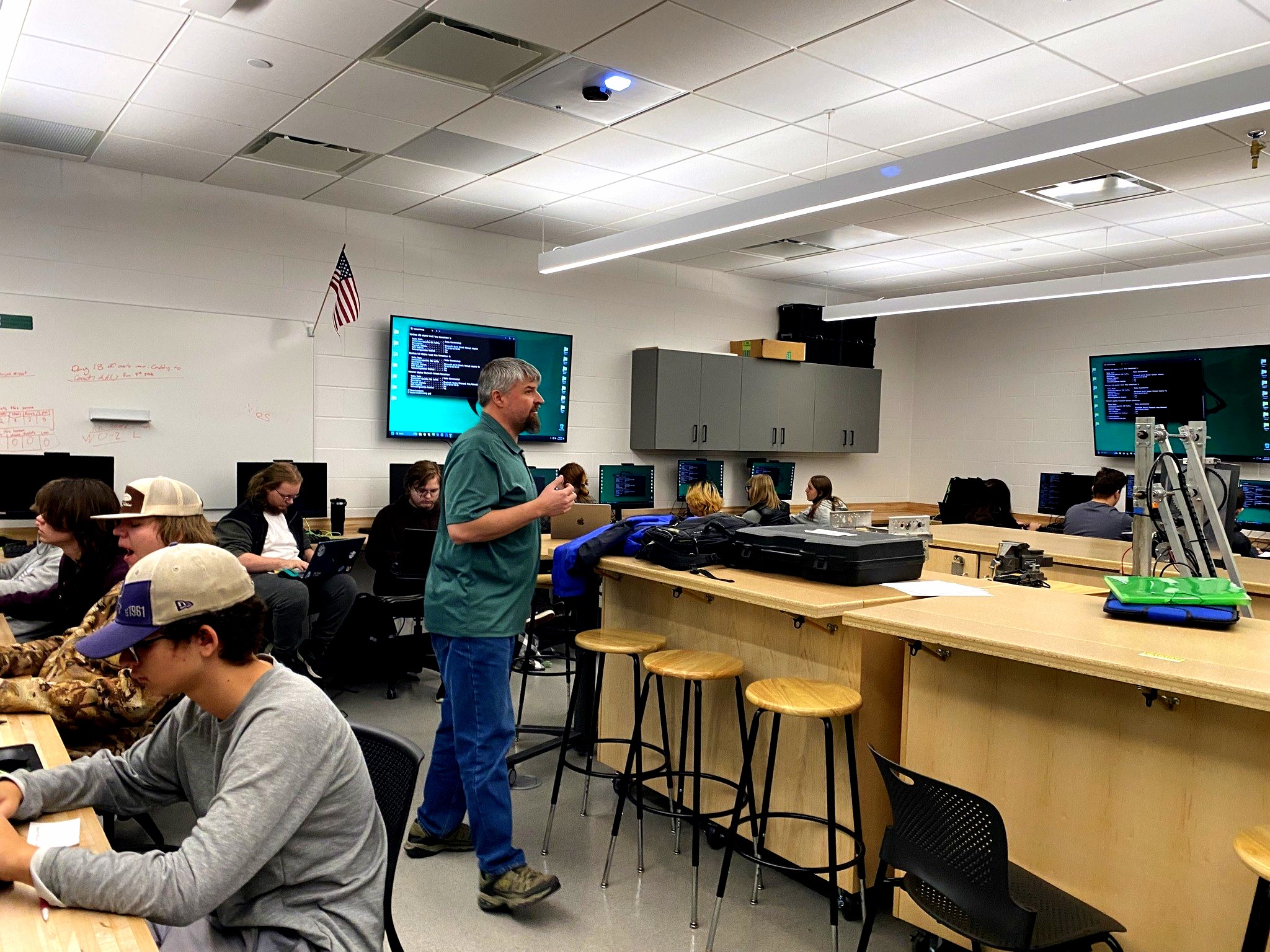 IT Networking and Security Instructor presenting in a classroom with computers to students