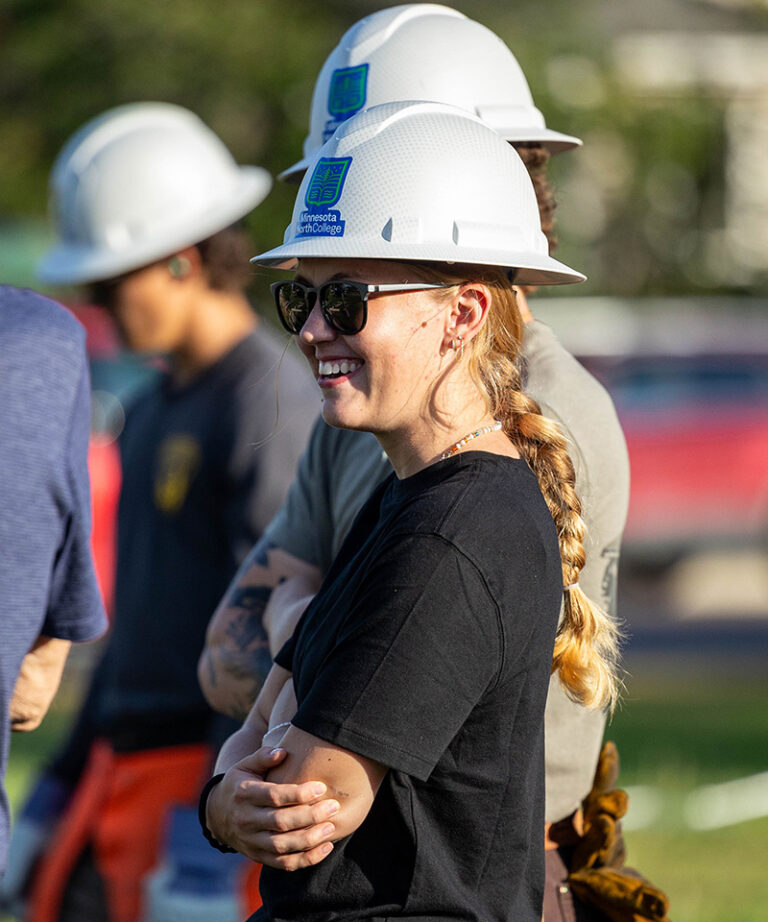 woman with minnesota north branded hard had smiling wearing sunglasses and a black short sleeve shirt