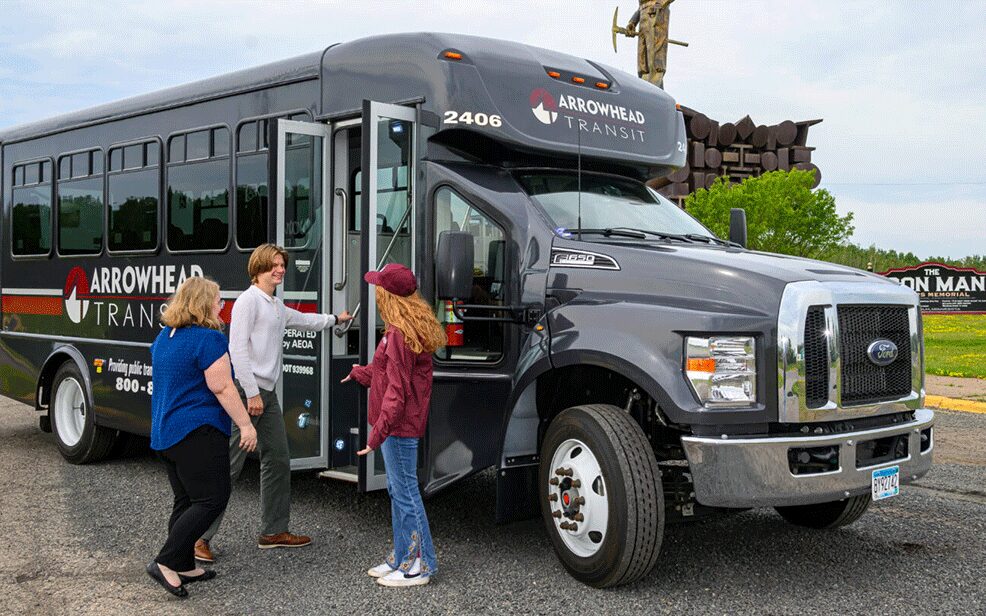 three students getting on the arrowhead transit bus