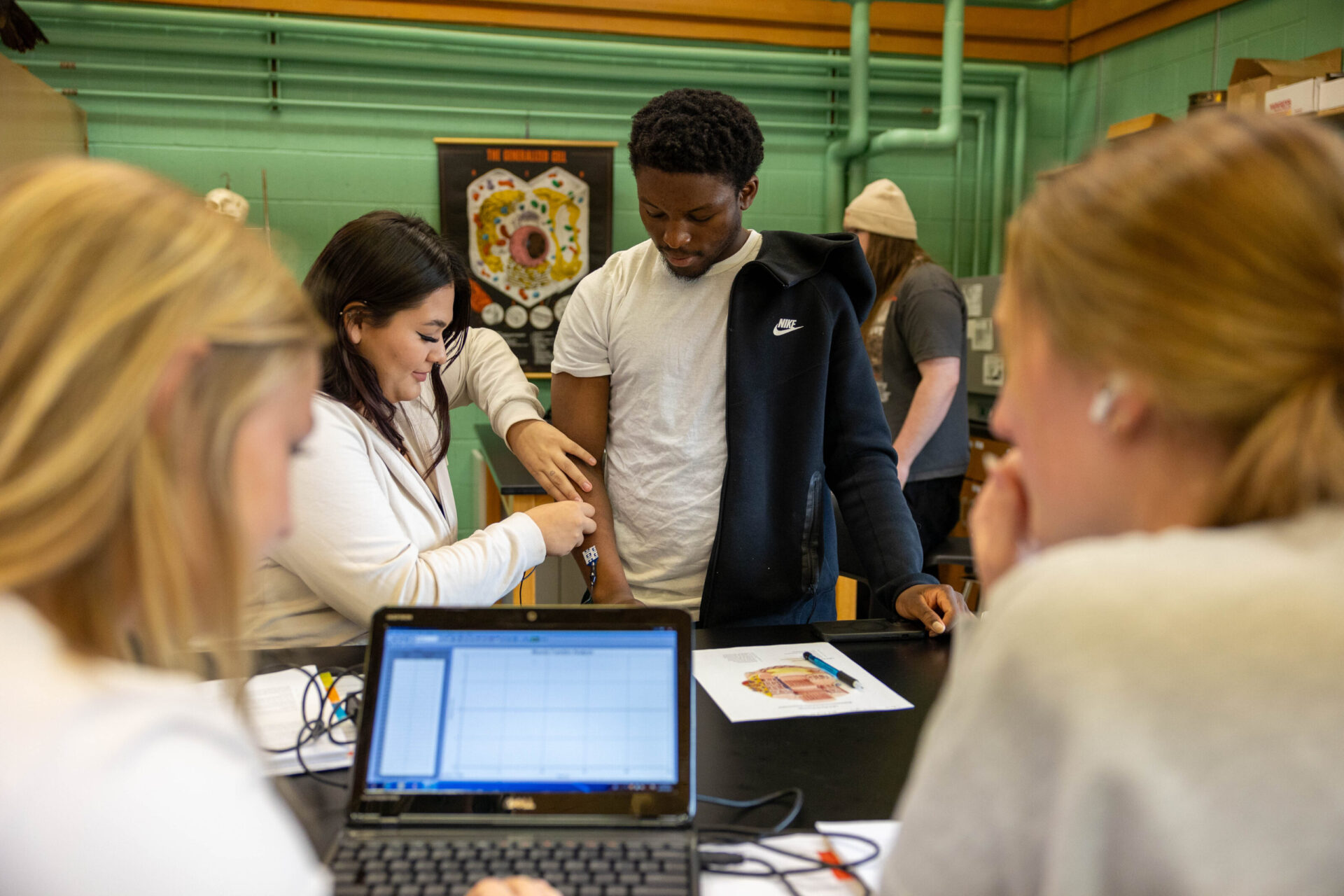 Four students performing an active experiment while learning in a science lab.